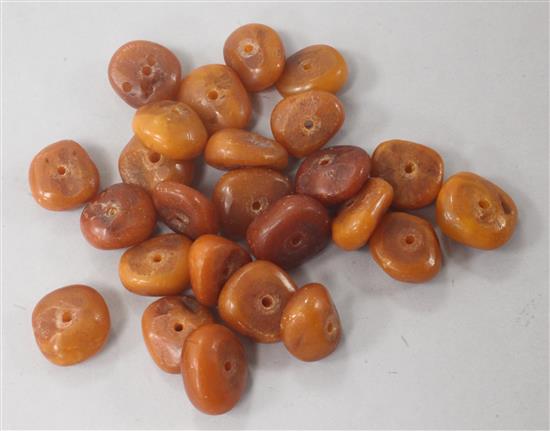 Twenty five loose amber beads, gross weight 60 grams.